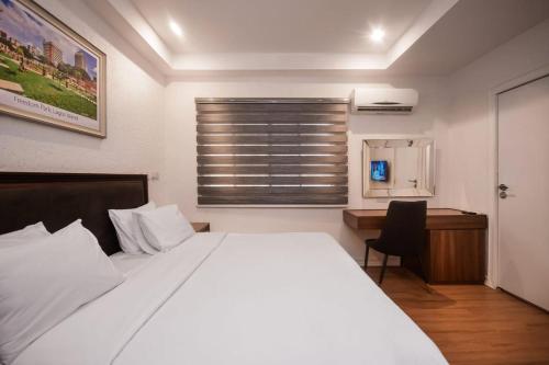 um quarto com uma cama, uma secretária e uma janela em Nicotel Apartments em Lekki