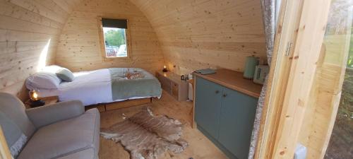 a small bedroom with a bed in a wooden cabin at Y Nyth - The nest in Bridgend