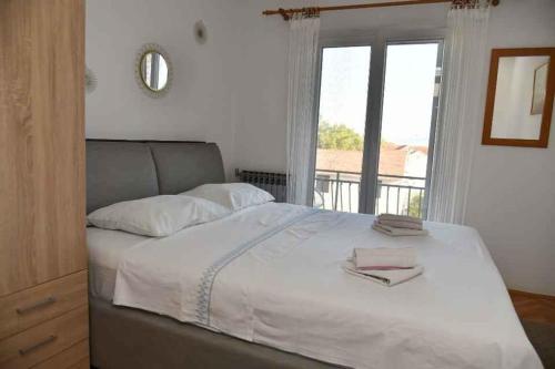 1 dormitorio con 1 cama blanca grande y ventana en Apartments in Supetar - Insel Brac 31170, en Supetar