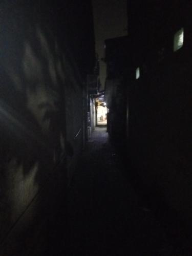 une chambre sombre avec une personne debout dans l'obscurité dans l'établissement Gondrong guest house, 