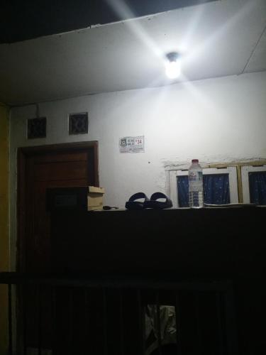 ein dunkles Zimmer mit einem Licht an der Wand und einer Decke in der Unterkunft Gondrong guest house 