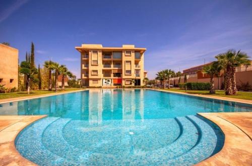 een groot zwembad voor een gebouw bij appartement moderne au style beldi résidence au centre de Marrakech avec piscine in Marrakesh