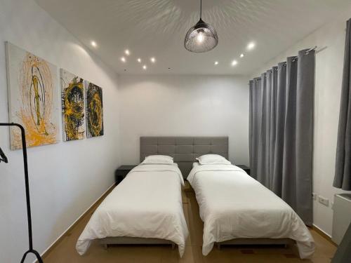 um quarto com três camas com um candeeiro em Proper Apartment 2 em Tirana