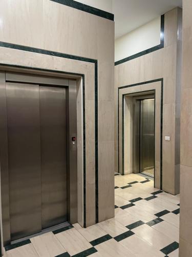 duas portas de elevador num edifício com piso em azulejo em Proper Apartment 2 em Tirana