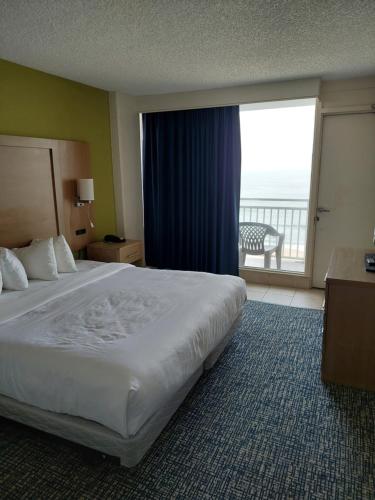 a hotel room with a bed and a large window at Comfort Suites Beachfront in Virginia Beach