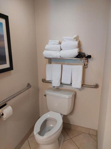a bathroom with a toilet and a bunch of towels at Comfort Suites Beachfront in Virginia Beach