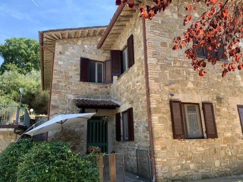 a stone building with an umbrella in front of it at Borgo Eva in Assisi