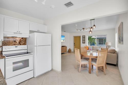 a kitchen and dining room with white appliances and a table at LoKal Rental Tropical Florida destination in Fort Lauderdale