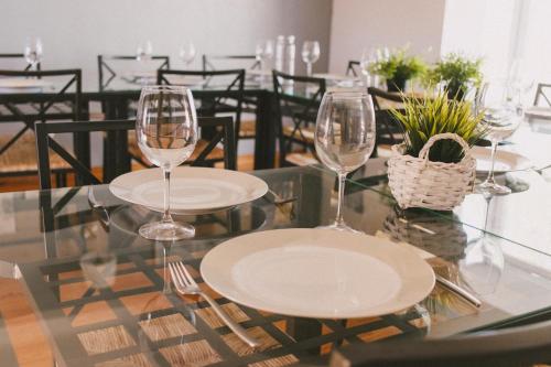 dos copas de vino sentadas en una mesa de cristal en Casas de Campo Villa D'Almeida en Travancinha