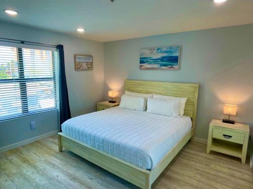 a bedroom with a bed with two night stands and two lamps at Vistalmar Beach Resort in Deerfield Beach