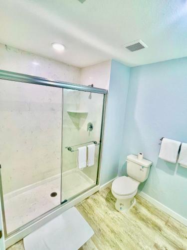 a bathroom with a glass shower and a toilet at Vistalmar Beach Resort in Deerfield Beach