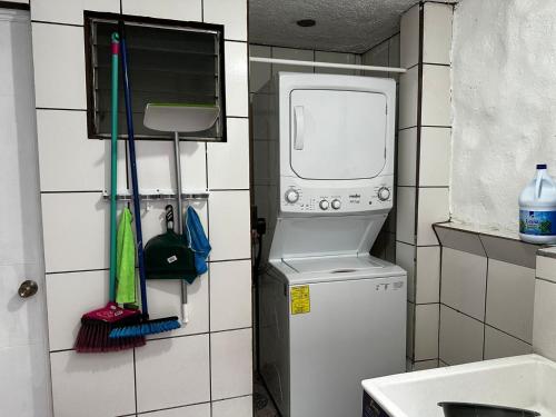 a small bathroom with a washing machine and a sink at Merliot, Sta Tecla Frente Cto Comer La Plaza Merliot in Nueva San Salvador