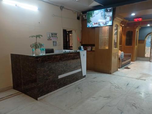 eine Lobby mit einer Theke und einem TV an der Wand in der Unterkunft OYO The Blue Sky Hotel And Resort in Gwalior