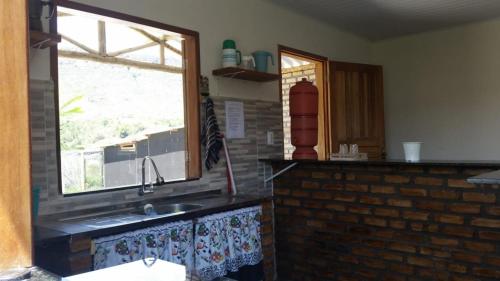 une cuisine avec un évier et une fenêtre dans l'établissement Chalet Vida de Roça, à Ibicoara