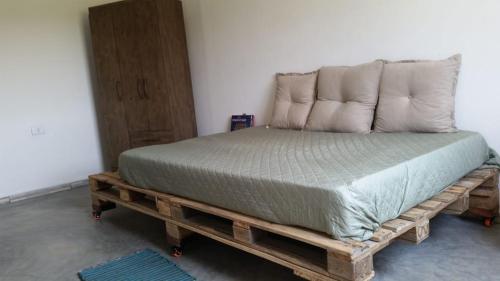 a bed on a wooden pallet in a room at Chalet Vida de Roça in Ibicoara