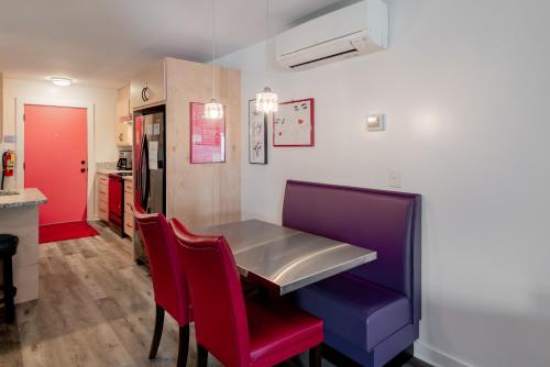 ein Esszimmer mit einem Tisch und roten und violetten Stühlen in der Unterkunft Folly Vacation Perfect Purple Palace Apt A in Folly Beach