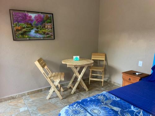 ein Schlafzimmer mit einem Tisch, Stühlen und einem Bett in der Unterkunft Bungalows Victoria in La Manzanilla