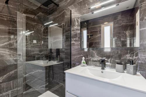 un baño con lavabo y espejo en Villa Estrela, en Lourinhã