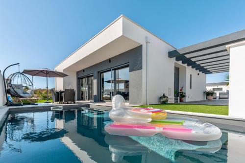 una piscina con un pato de goma en una casa en Villa Estrela, en Lourinhã