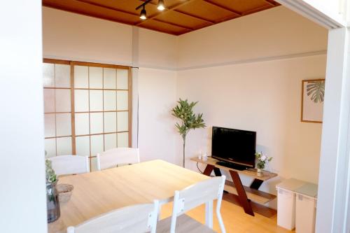 a dining room with a table and a television at Daiichi Mitsumi Corporation - Vacation STAY 15393 in Musashino