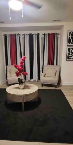 a living room with a couch and a table with flowers at Luxurious 3 Story Townhome in Charlotte