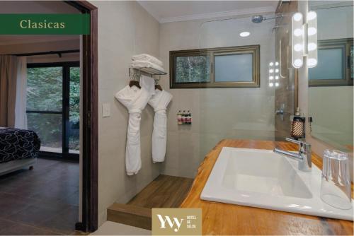 uma casa de banho com um lavatório e um espelho em Yvy Hotel de Selva em Porto Iguaçu