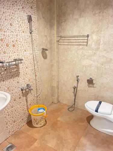 a bathroom with a shower and a toilet and a sink at Chola Heritage Resort in Kāraikkudi