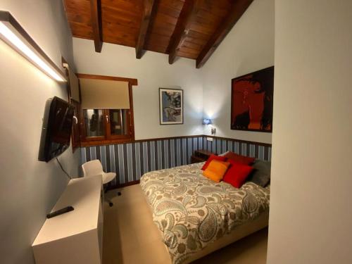 a bedroom with a bed and a desk with a television at La Traviesa,Villa de Lujo de 500 m. en el Campo con Piscina 
