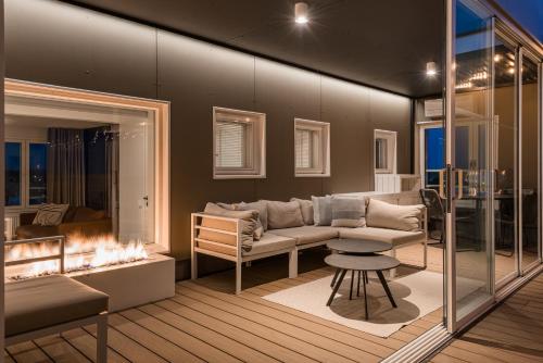 un soggiorno con divano e camino di Prime Penthouse Central - jacuzzi and sauna a Pori