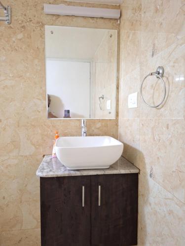 a bathroom with a sink and a mirror at Suvarna Grande Homes in Mangalore