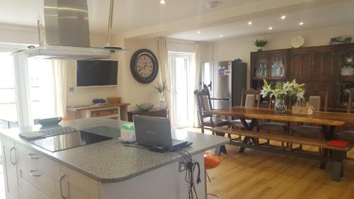 a kitchen and dining room with a table and a laptop at Home away from home in Mildenhall