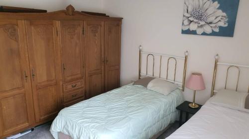 sypialnia z 2 łóżkami i dużą drewnianą szafką w obiekcie Home away from home w mieście Mildenhall
