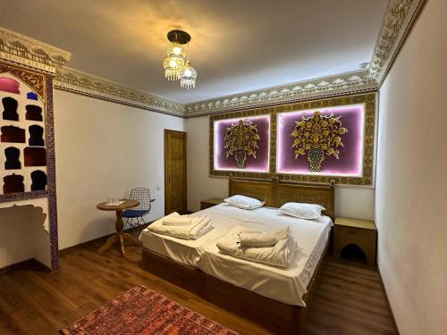 1 dormitorio con cama y pared púrpura en Tasvir Hotel, en Bukhara