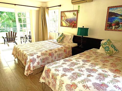 a hotel room with two beds and a window at Mystic Ridge Apt 2 Plus 6 in Ocho Rios