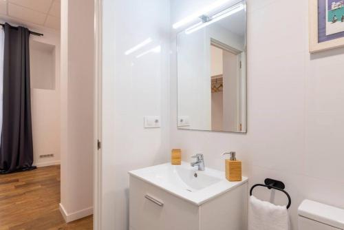 Baño blanco con lavabo y espejo en Elegante 1Bdr Loft en el centro, en Santander