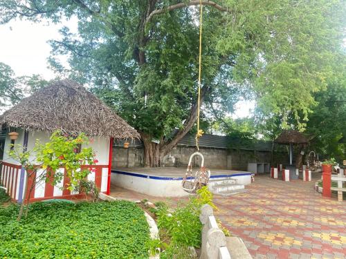 a house with a swimming pool in a yard at Chola Heritage Resort in Kāraikkudi