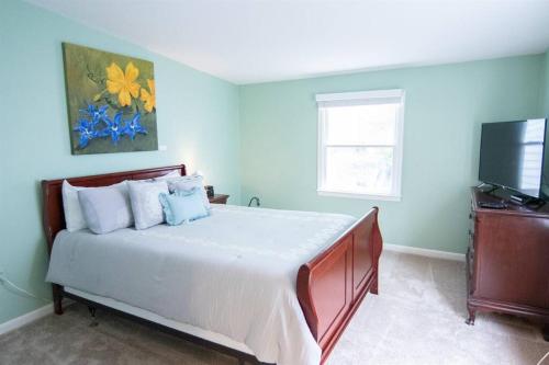 a bedroom with a large bed and a television at Cozy 2br home w/ parking in downtown Annapolis in Annapolis