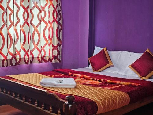 1 dormitorio con 1 cama con paredes moradas en Cicily Holidays Inn, en Munnar