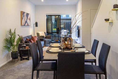 a dining room and living room with a table and chairs at Central city executive hideaway 5 mins to Hagley park Riverside 4 beds 4 bath in Christchurch