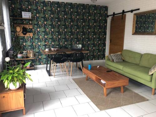 ein Wohnzimmer mit einem grünen Sofa und einem Tisch in der Unterkunft Comme à la maison in Marsan