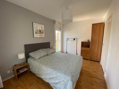 a bedroom with a bed and a wooden floor at Appart T2 quartier santé et Agro in Rennes