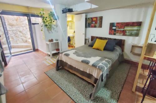Dormitorio con cama con almohada amarilla en Hachazuelas7, en Moralzarzal