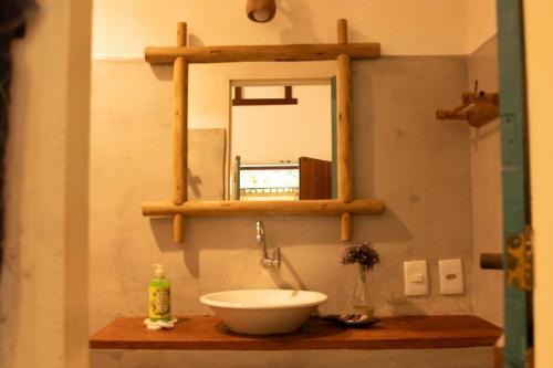 a bathroom with a sink and a mirror at Suites da Loja Caraíva in Porto Seguro
