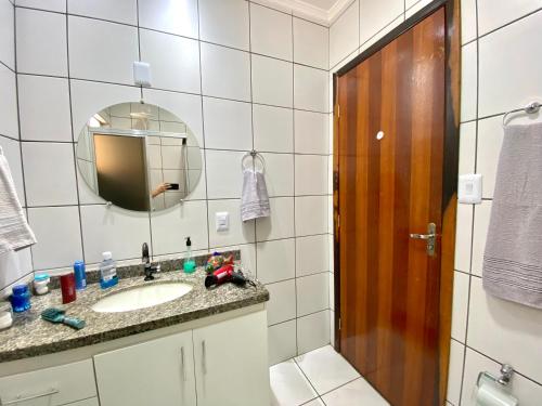 uma casa de banho com um lavatório e um espelho em Apto charmoso e espaçoso no Centro, térreo com 2 Quartos ArCond WiFi HomeOfice Cozinha e Garagem em Dourados