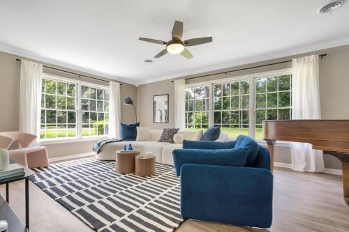 a living room with a piano and blue chairs at Cozy - Organic Modern - Bungalow - FSU in Tallahassee