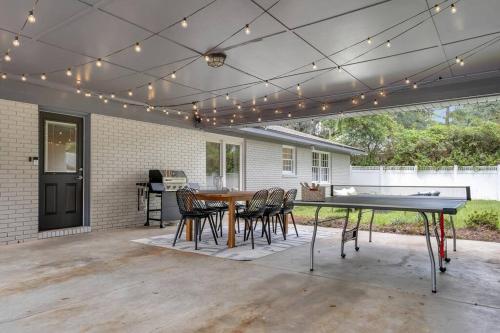 a patio with a ping pong table and chairs at Cozy - Organic Modern - Bungalow - FSU in Tallahassee