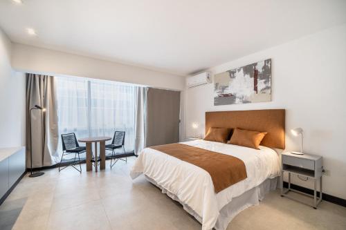 1 dormitorio con 1 cama, mesa y sillas en La Vie Madero en Buenos Aires