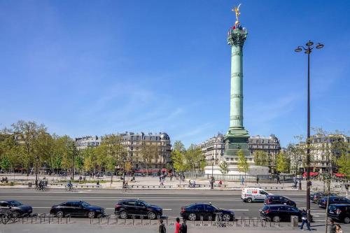 a parking lot with cars parked in front of a monument at Studio calme à Bastille, proche Seine & Gare de Lyon in Paris