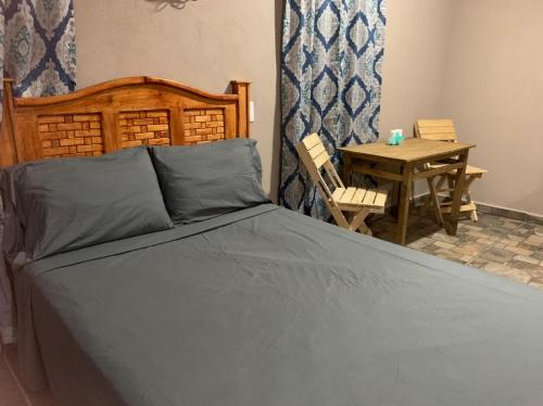 a bedroom with a large bed and a table at Bungalows Victoria in La Manzanilla