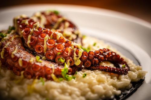 a plate of food with aopus on top of rice at Porto Pacuíba Hotel in Ilhabela